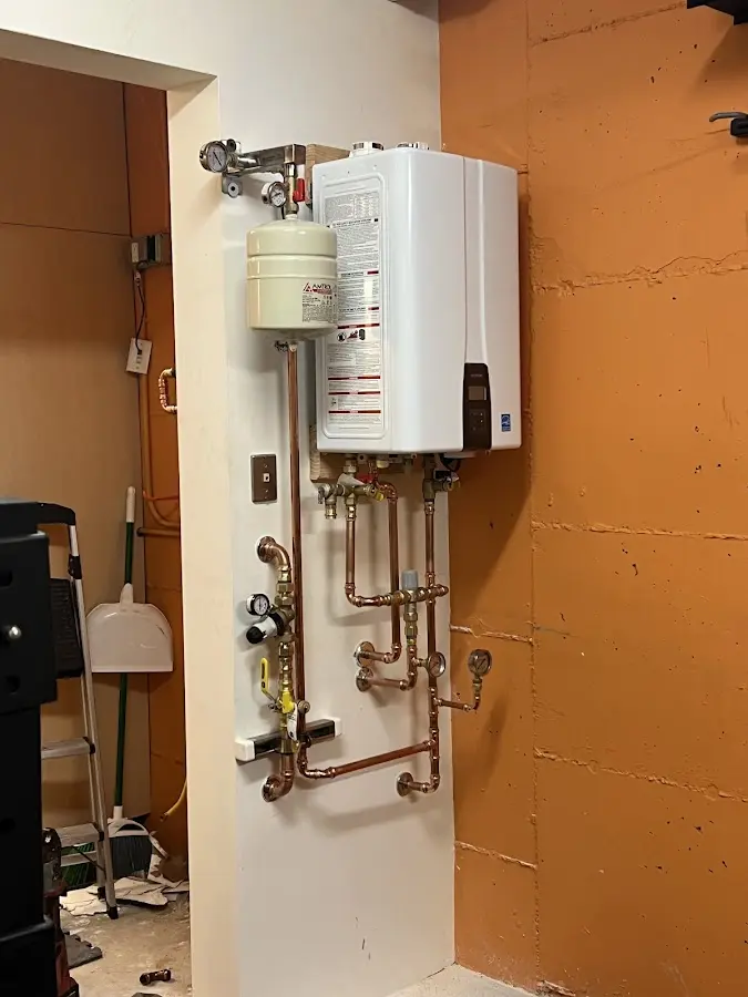 Plumbing technician inspecting water heater connections in Red Oak